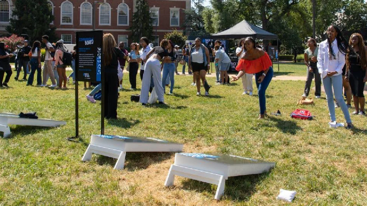 Young woman plays cornhole on a college campus at the Chase Back to the Yard tour managed by Fuller Street