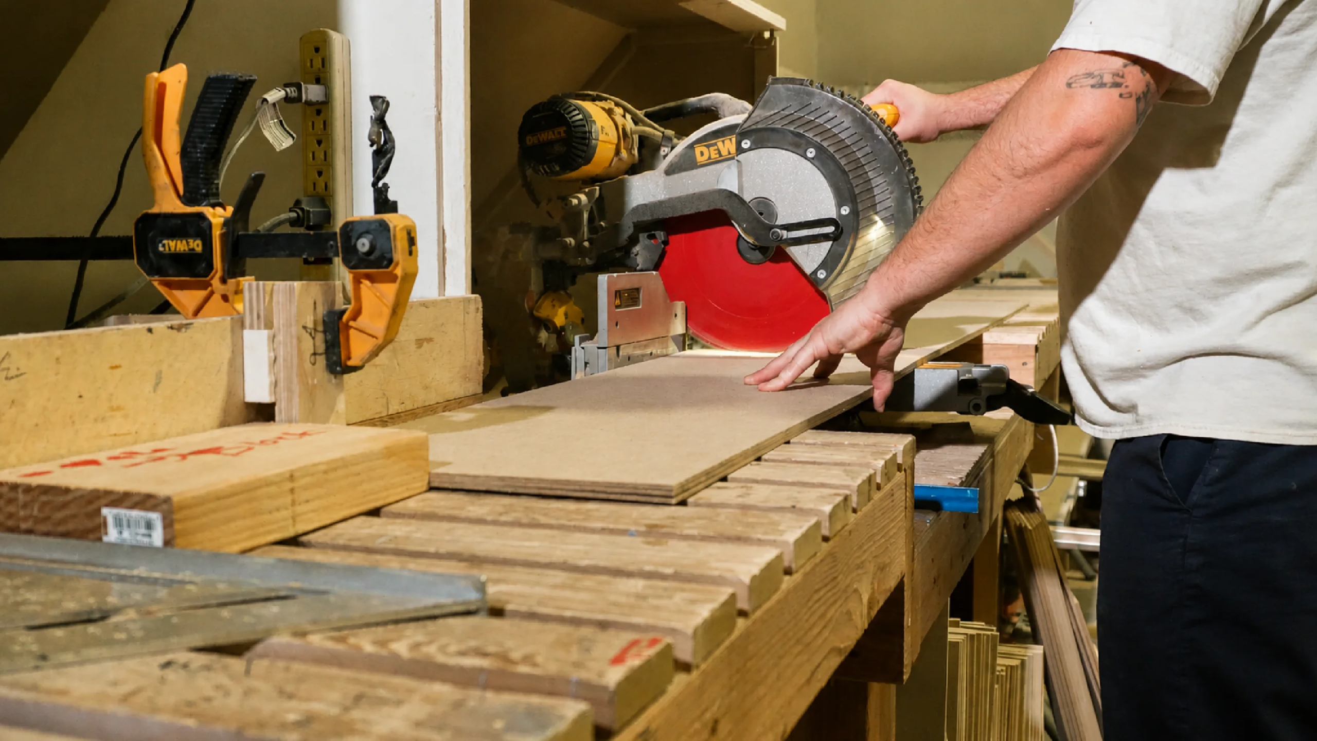 A carpenter uses a miter saw to cut wood for experiential fabrication services by Fuller Street in Los Angeles